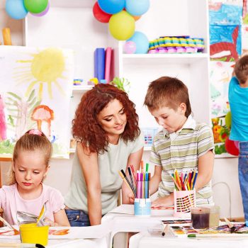 Teacher helping student with artwork