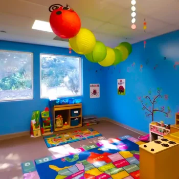 A giant caterpillar in a blue preschool classroom