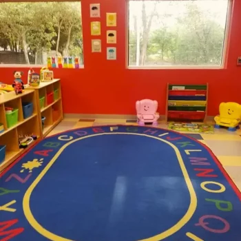 A play area in a classroom with red walls and big windows